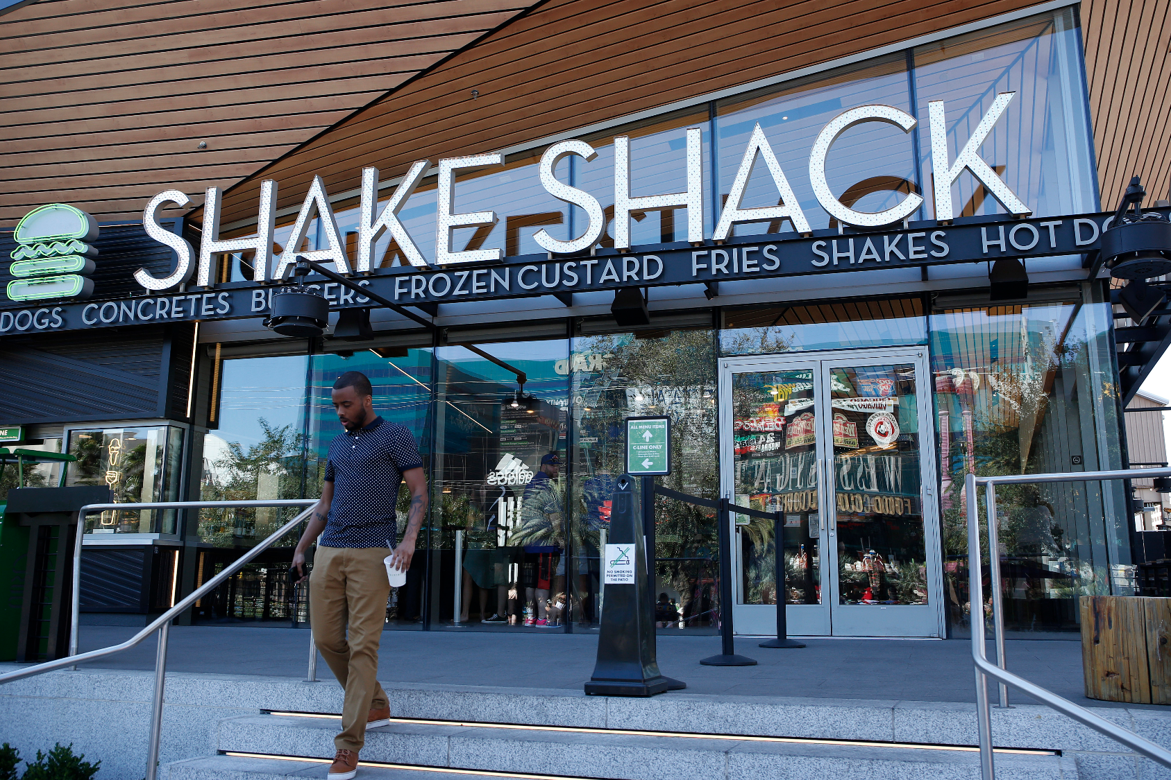 A man walks out of the Shake Shack in front of the New York-New York hotel and casino in Las Vegas. Shake Shack on Monday, Aug. 10, 2015 said that price hikes and the return of its crinkle-cut French fries helped lift sales 12.9 percent at established locations during the second quarter, and raised its outlook for the year. / <a href='John Locher'>Associated Press</a>