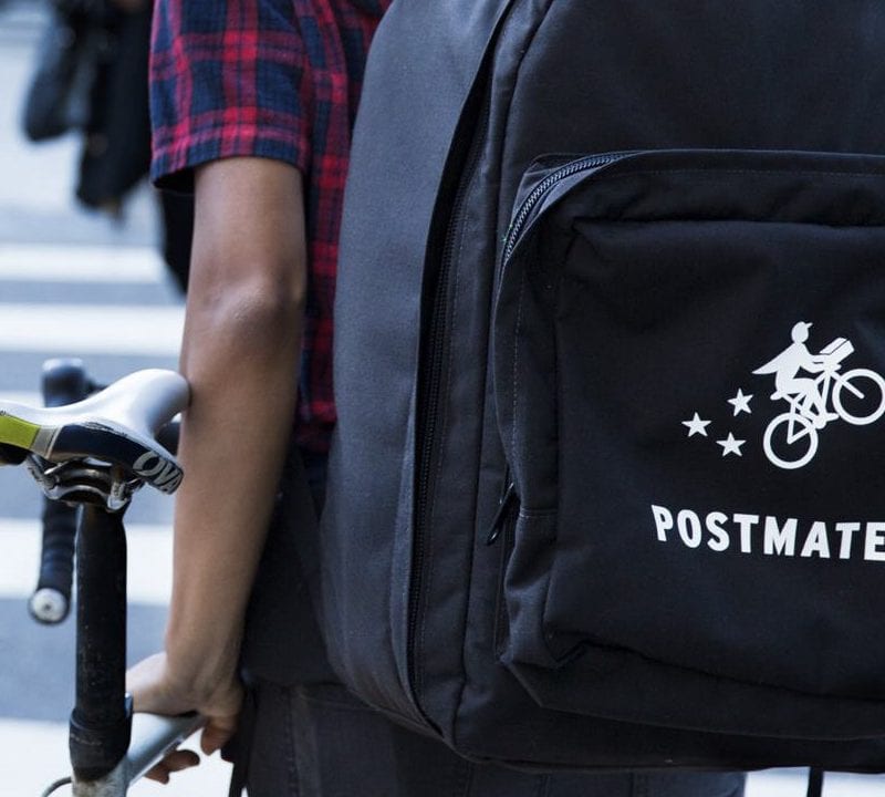 Promotional photo of a Postmates' delivery person. / Postmates
